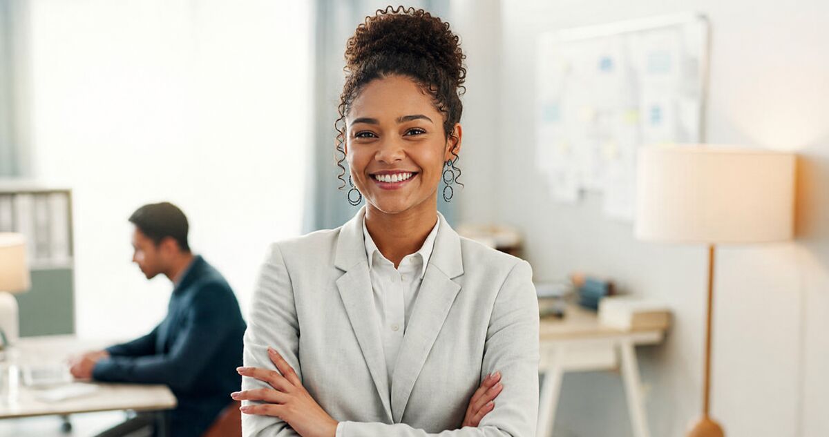 A confident young South African professional standing in a modern open-plan office